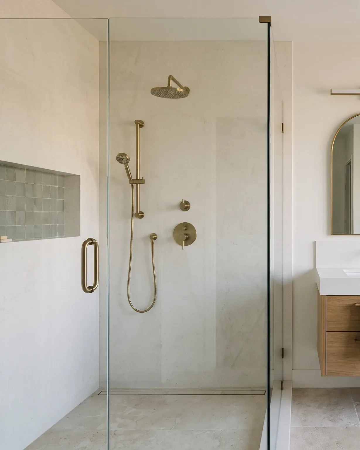 Glass walk-in shower with brushed-brass fixtures