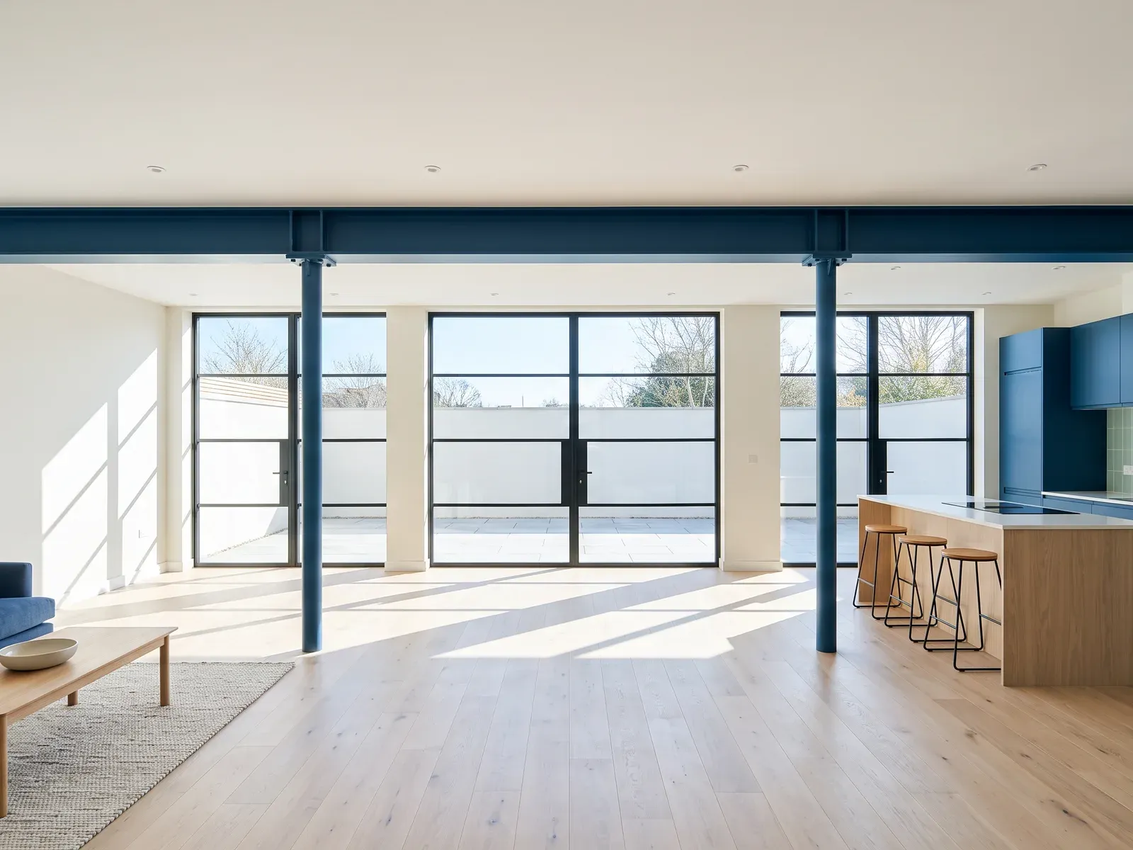 Open-plan living and kitchen with a long steel beam where a bearing wall stood